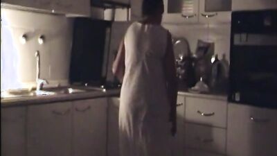 Naughty mature woman gets naked and touches herself in the kitchen