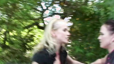 Two slutty girls are making out and sucking cock in the park