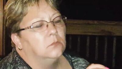 Amateur mature is smoking a cigarette in front of the camera