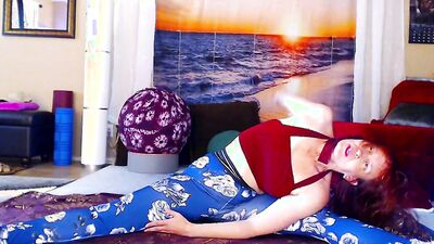 Redheaded chick is practicing some yoga in front of the cam